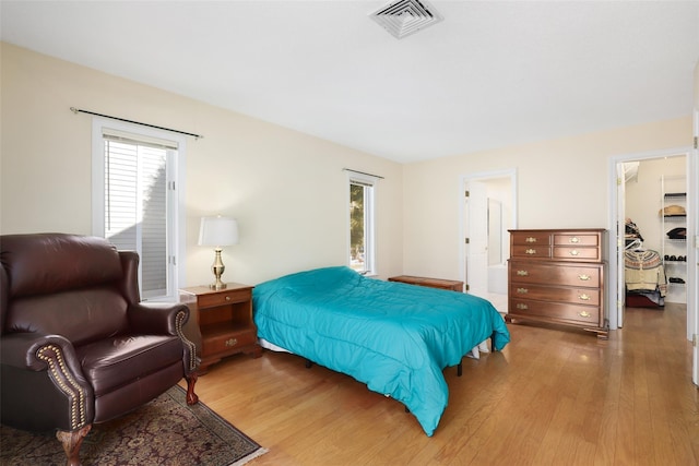 bedroom with hardwood / wood-style flooring and a spacious closet