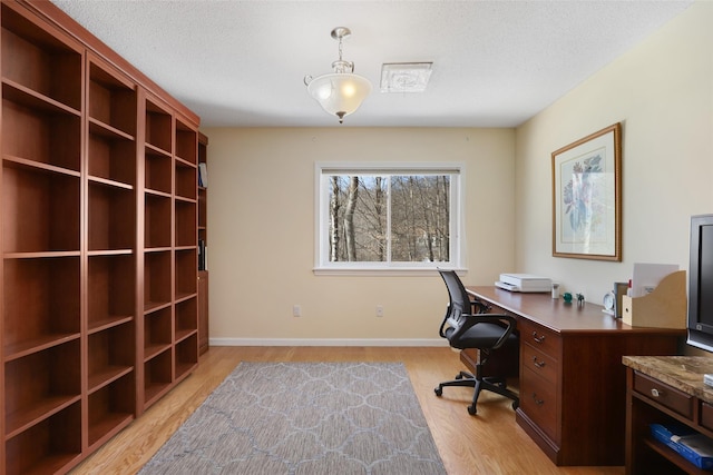 office with light hardwood / wood-style flooring and a textured ceiling