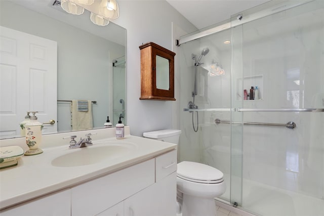 bathroom featuring vanity, a shower with shower door, and toilet