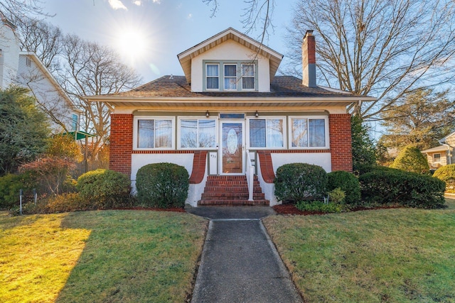 bungalow-style house featuring a front lawn