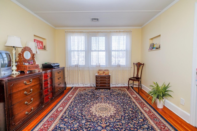 sitting room with crown molding and hardwood / wood-style floors