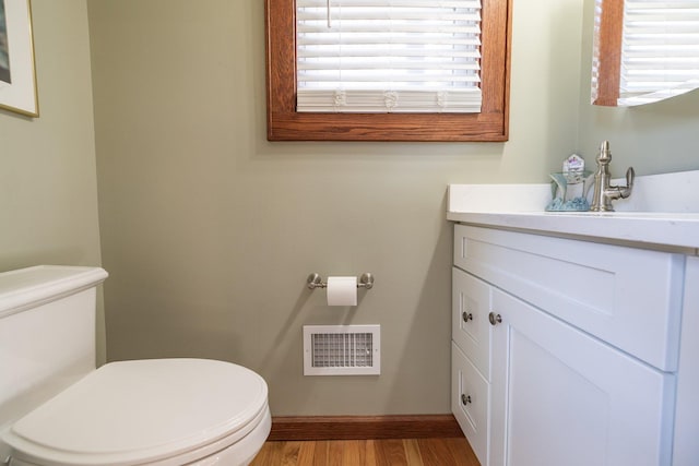 bathroom featuring vanity, hardwood / wood-style floors, and toilet