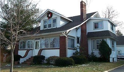 view of front of house with a sunroom and a front lawn