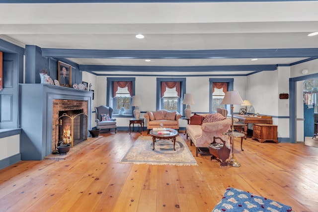 living room with hardwood / wood-style flooring, a fireplace, and beam ceiling