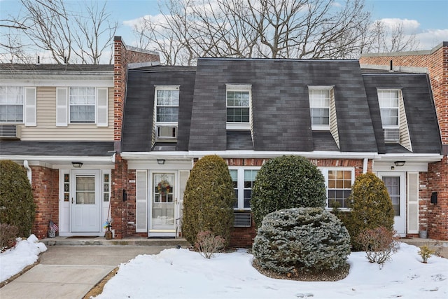 view of front of property with brick siding and roof with shingles