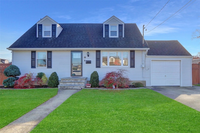 cape cod house featuring a garage and a front lawn