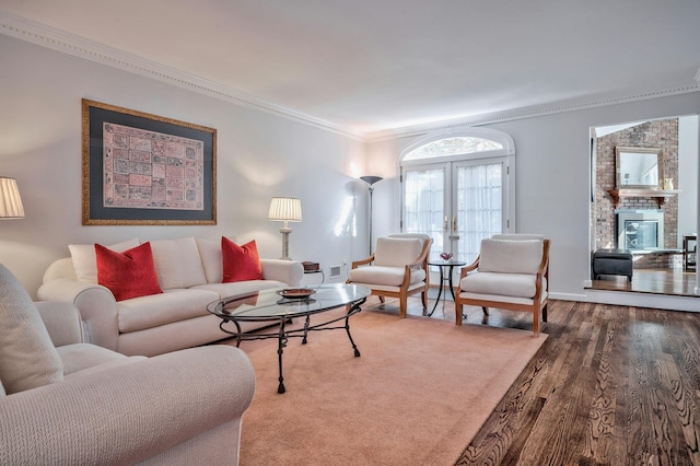 living room featuring french doors, a fireplace, crown molding, and hardwood / wood-style flooring