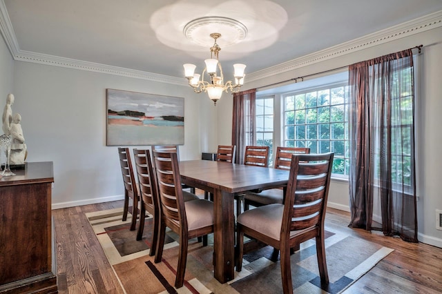 dining space featuring wood-type flooring, crown molding, and a chandelier