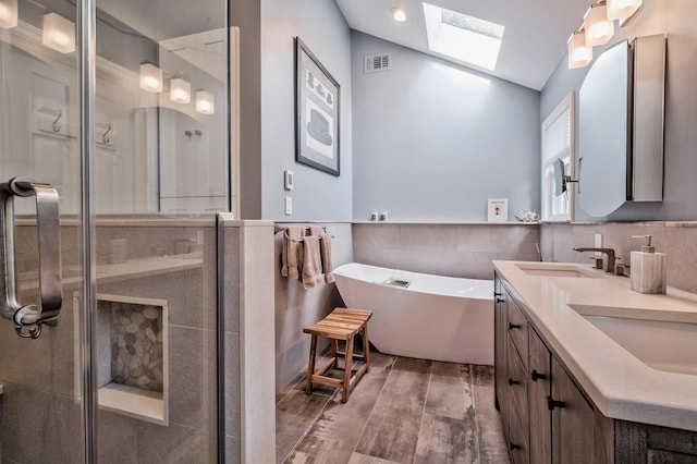 bathroom featuring hardwood / wood-style flooring, vanity, separate shower and tub, and tile walls