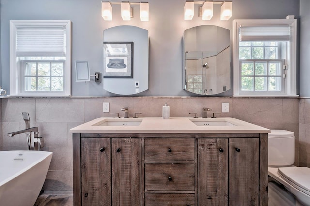 full bathroom with vanity, toilet, independent shower and bath, and tile walls