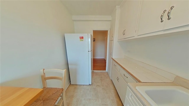 kitchen with white fridge and white cabinets