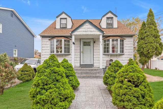 cape cod home featuring a front lawn