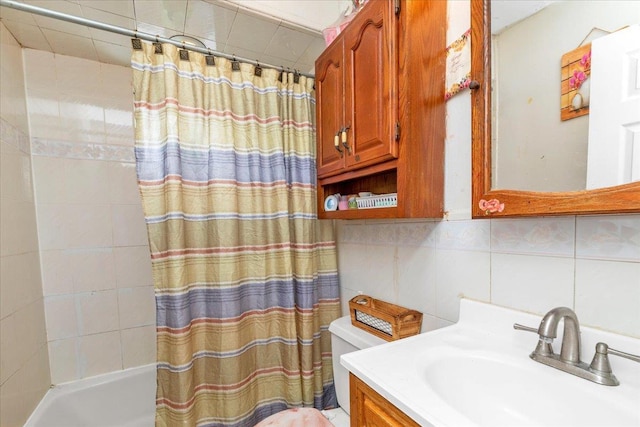 full bathroom with shower / tub combo with curtain, toilet, tile walls, vanity, and decorative backsplash