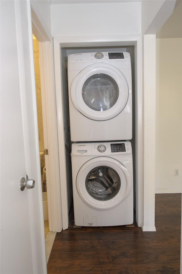 laundry room with stacked washer / dryer and dark hardwood / wood-style flooring