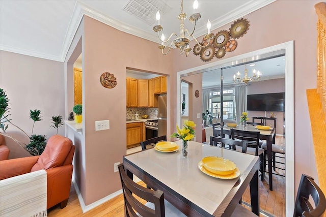 dining area with crown molding, a chandelier, and light hardwood / wood-style flooring