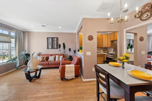 living room featuring ornamental molding, an inviting chandelier, and light hardwood / wood-style flooring