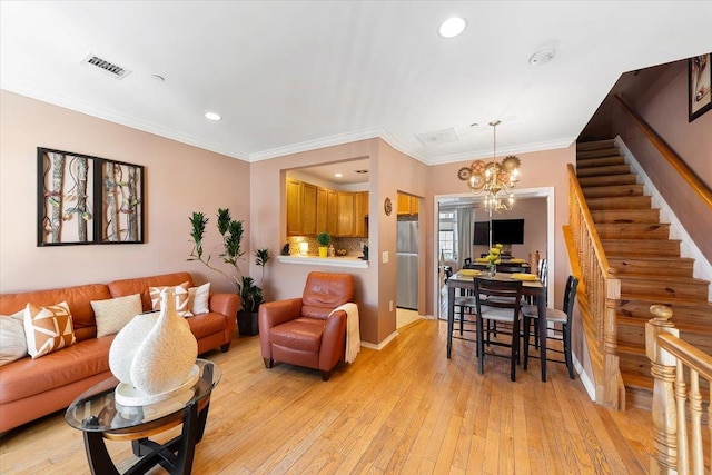 living room featuring crown molding, an inviting chandelier, and light hardwood / wood-style flooring