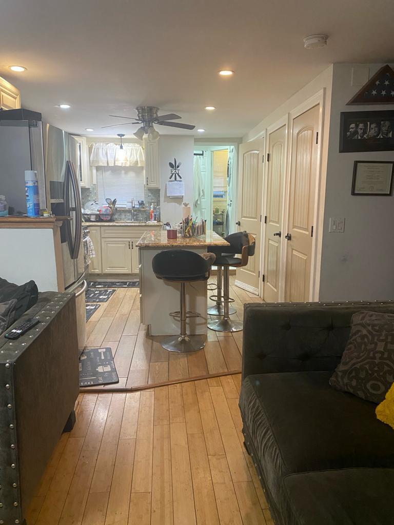 kitchen with sink, white cabinets, a kitchen breakfast bar, and light hardwood / wood-style flooring