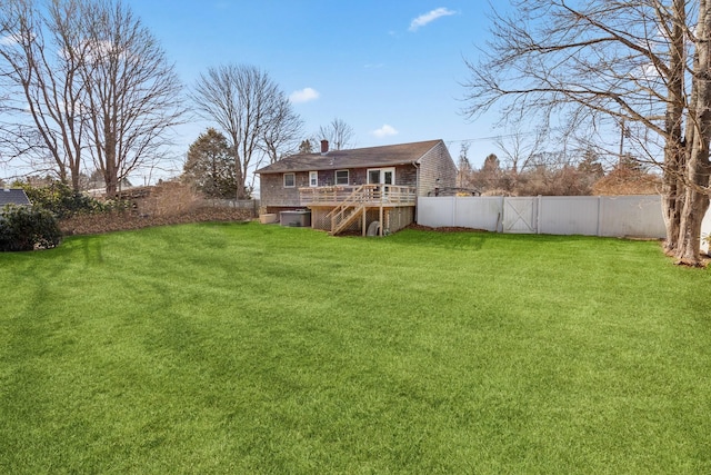 rear view of house featuring a yard and a deck