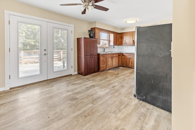 kitchen featuring stainless steel fridge, light hardwood / wood-style floors, french doors, and ceiling fan