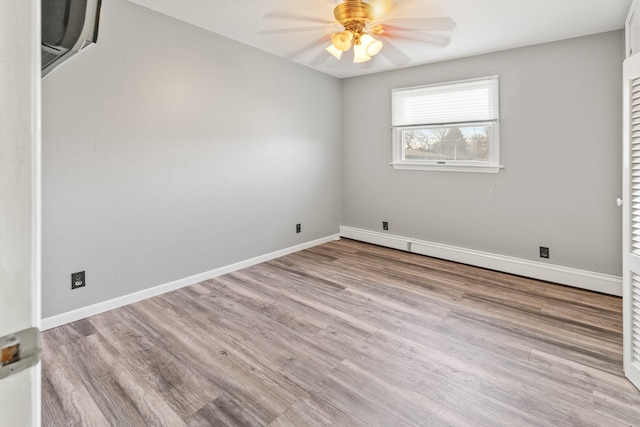 spare room featuring a baseboard heating unit, light hardwood / wood-style flooring, and ceiling fan