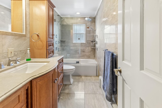 full bathroom featuring toilet, combined bath / shower with glass door, tasteful backsplash, tile walls, and vanity