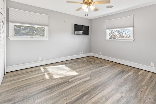 unfurnished room with plenty of natural light, ceiling fan, and light wood-type flooring