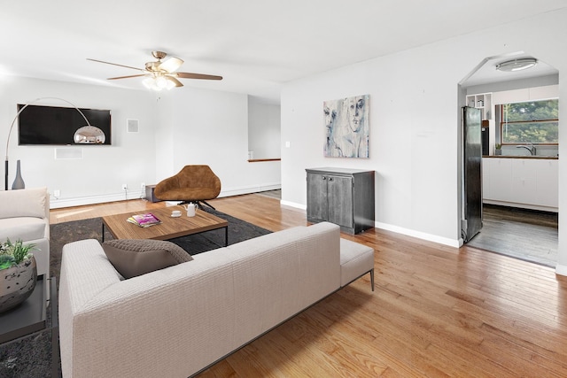 living room featuring ceiling fan and hardwood / wood-style floors