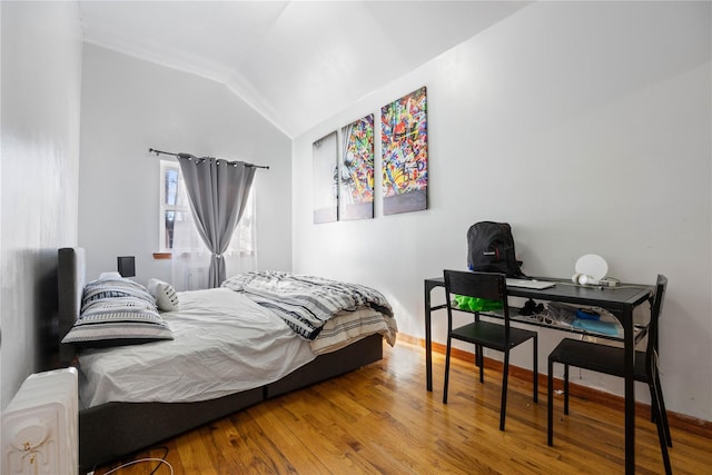 bedroom featuring radiator, vaulted ceiling, and hardwood / wood-style floors