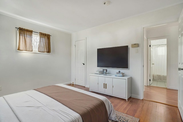 bedroom with crown molding and light hardwood / wood-style flooring