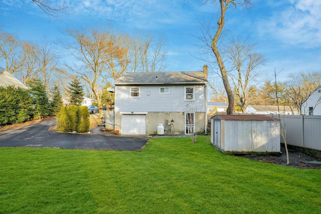 back of house with a storage shed and a yard