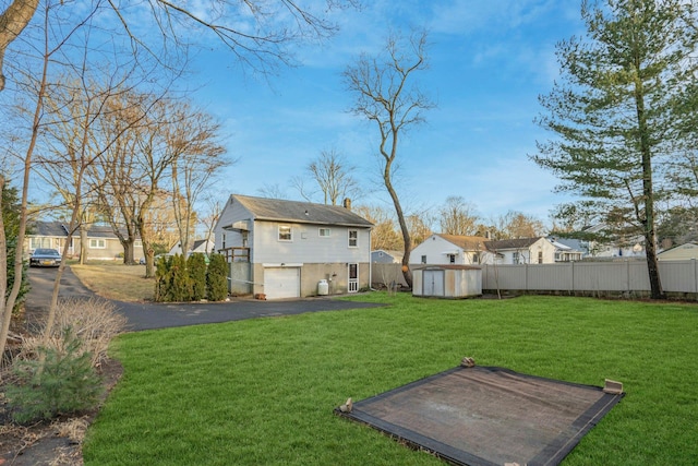 view of yard featuring a garage and a storage shed