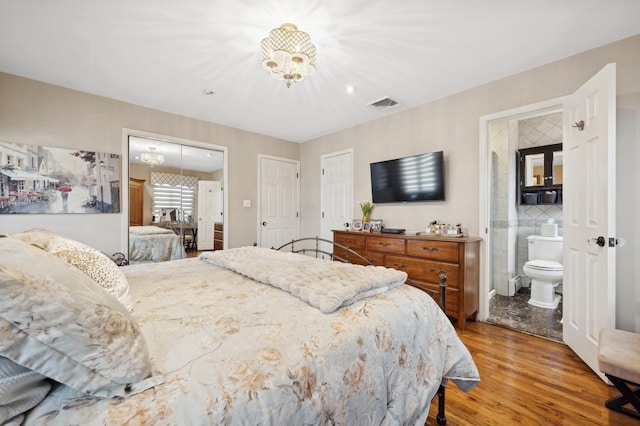 bedroom with wood-type flooring and ensuite bathroom