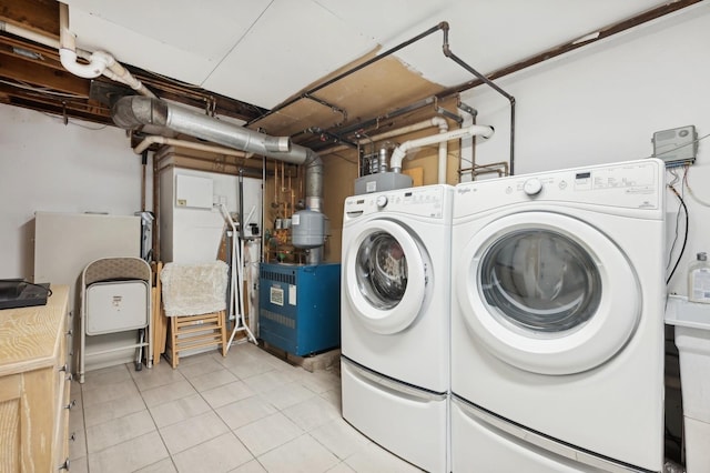 clothes washing area with separate washer and dryer and light tile patterned floors