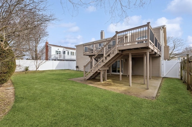 rear view of property with a yard, a patio, and a deck