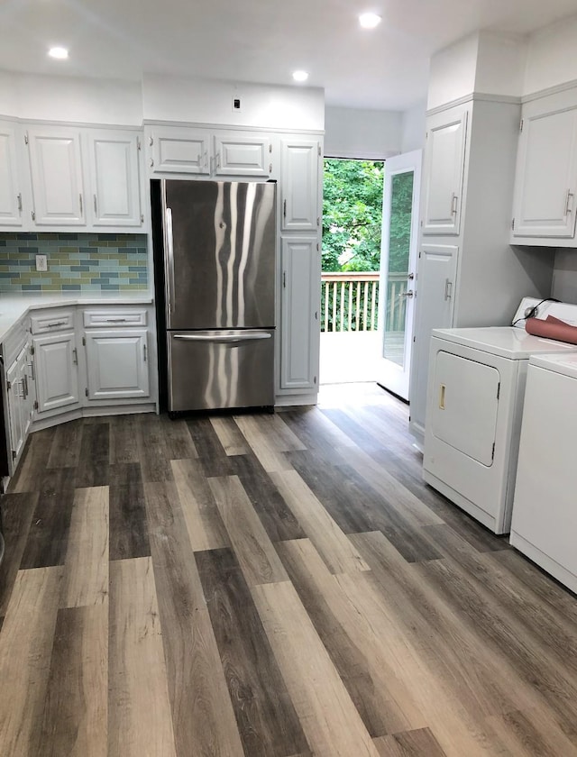 kitchen with white cabinetry, dark wood-type flooring, stainless steel refrigerator, and washing machine and clothes dryer