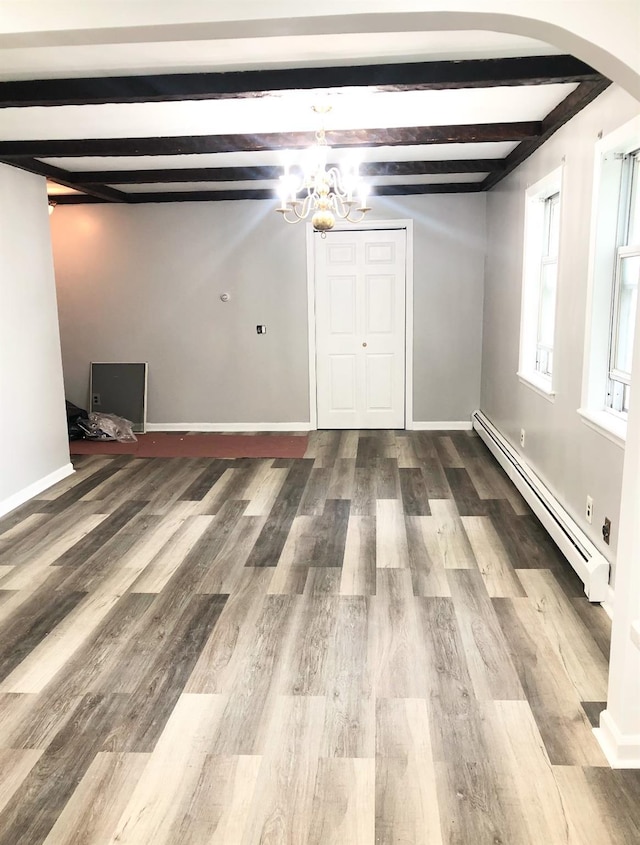 unfurnished room with beamed ceiling, wood-type flooring, a notable chandelier, and baseboard heating