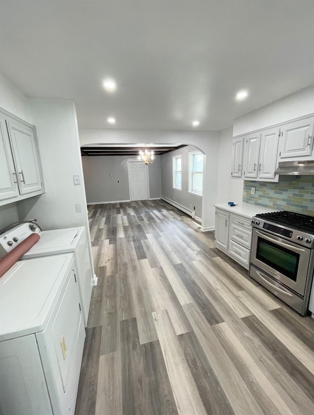 kitchen with washer and clothes dryer, white cabinetry, tasteful backsplash, gas range, and a baseboard radiator