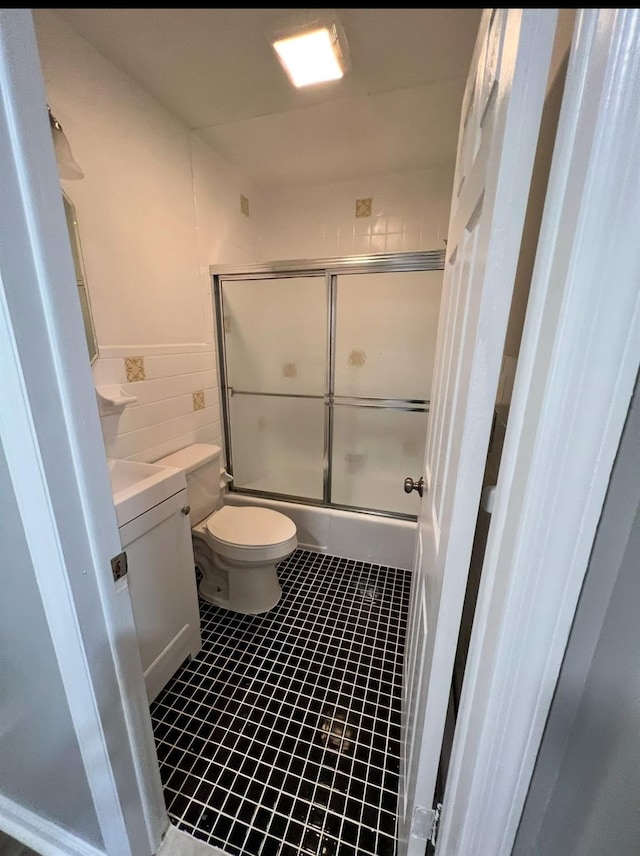 full bathroom featuring shower / bath combination with glass door, vanity, toilet, and tile patterned flooring