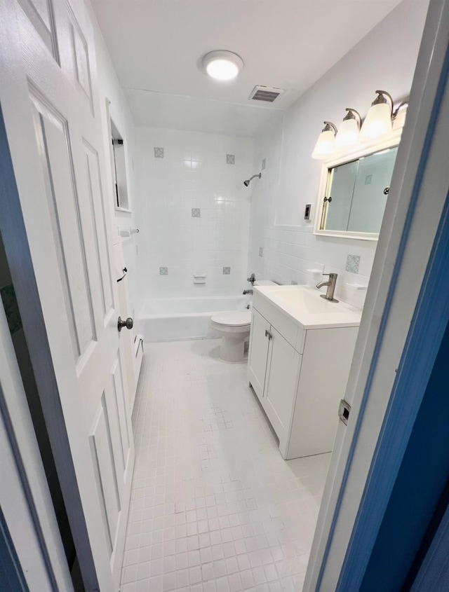 full bathroom with tile patterned floors, toilet, tile walls, vanity, and tiled shower / bath combo