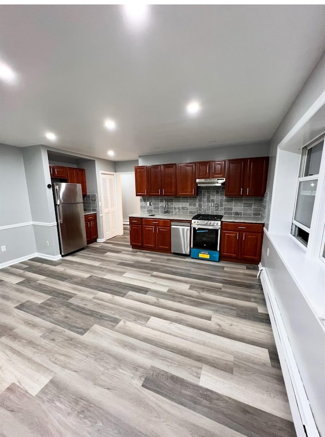 kitchen with stainless steel appliances, backsplash, and light hardwood / wood-style floors