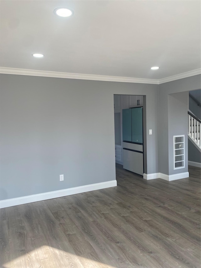 spare room with ornamental molding and dark hardwood / wood-style floors