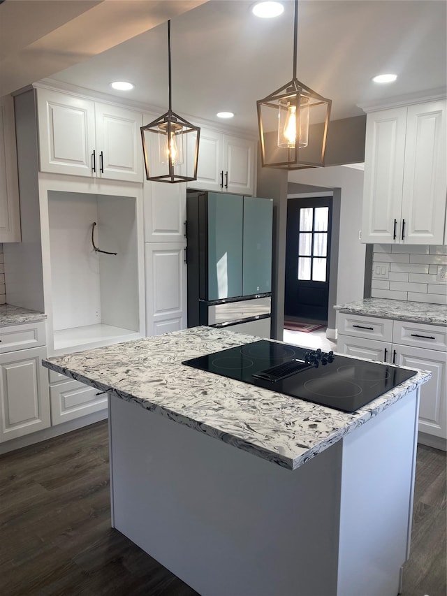 kitchen with dark hardwood / wood-style floors, pendant lighting, refrigerator, tasteful backsplash, and white cabinets