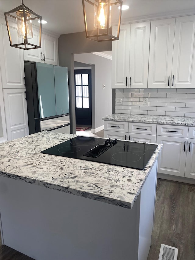 kitchen featuring white cabinetry, pendant lighting, backsplash, and refrigerator