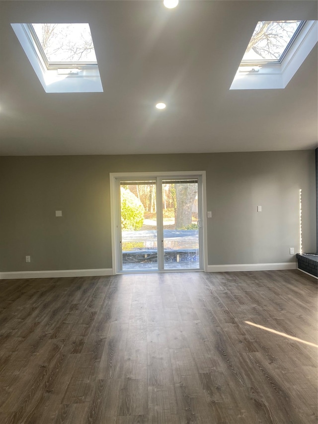 interior space with dark hardwood / wood-style flooring and vaulted ceiling with skylight