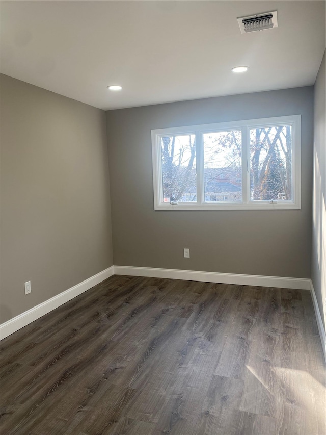 spare room featuring dark wood-type flooring