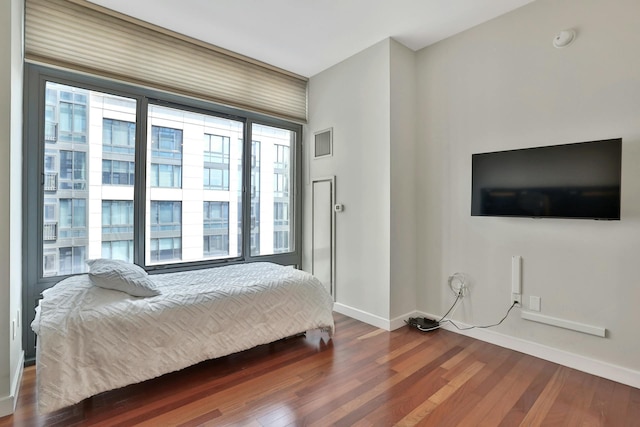 bedroom with dark hardwood / wood-style flooring