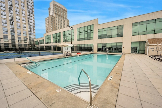 view of swimming pool with tennis court