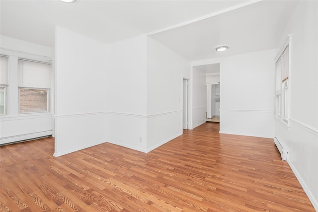 unfurnished room with light hardwood / wood-style flooring and a baseboard heating unit