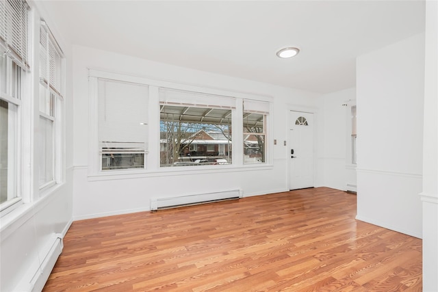 empty room with light wood-type flooring and baseboard heating